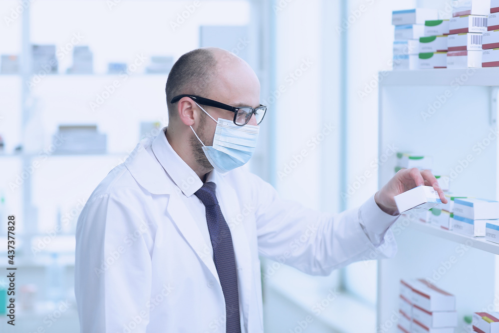Pharmacist is Working. Man Wearing Special Medical Uniform. Located in Pharmacy.