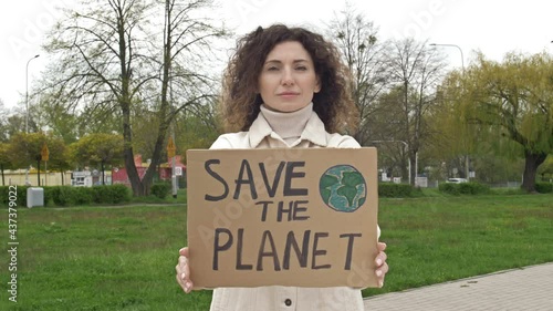 Woman with a poster SAVE THE PLANET. Feasible contribution to the fight against global pollution of nature. Single picket. photo