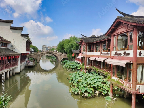 Qibao Water town. Old Chinese houses on the banks of the canal. Bridge with tourists across the river. Shanghai. China. Asia