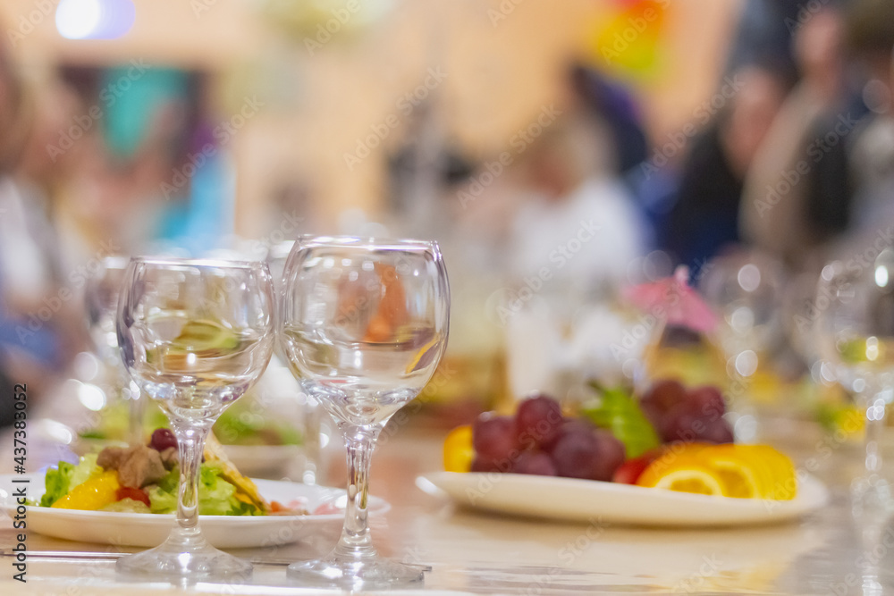 A feast in a cafe, a Russian holiday, the table is covered with glasses, Fruit, plates with salad