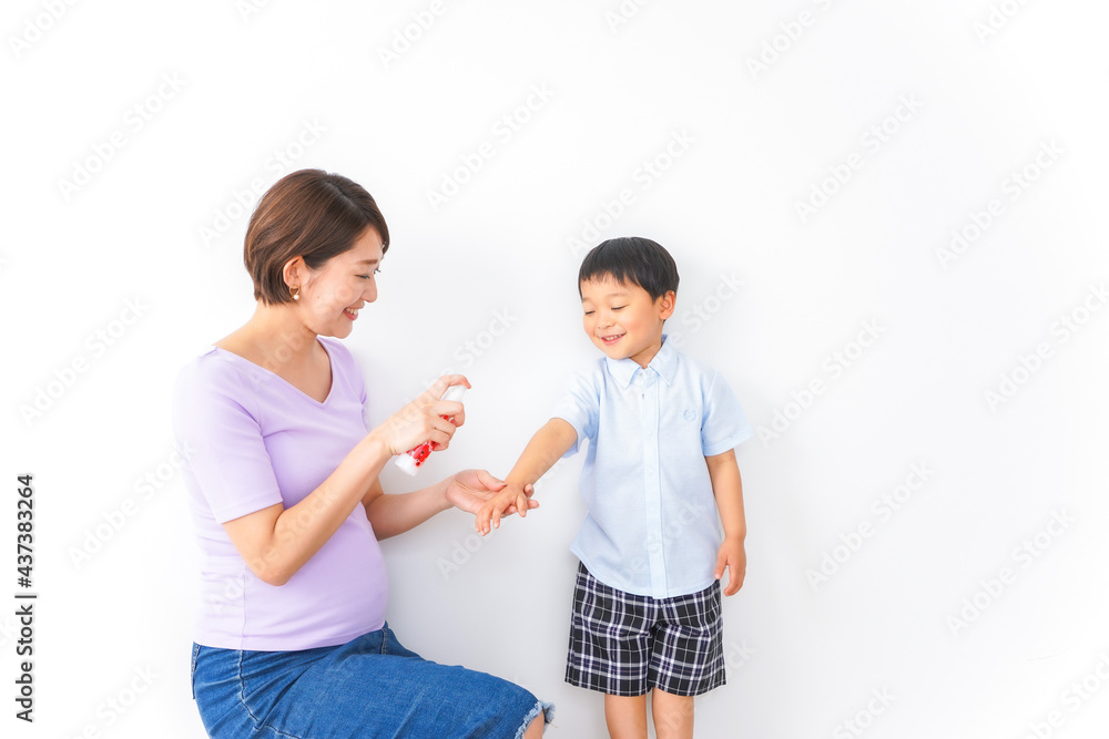 子どもにスプレーをするお母さん