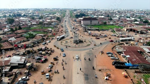 Road traffic in Minna, Nigeria's Niger State with a view of the traffic and city - push in descending aerial view