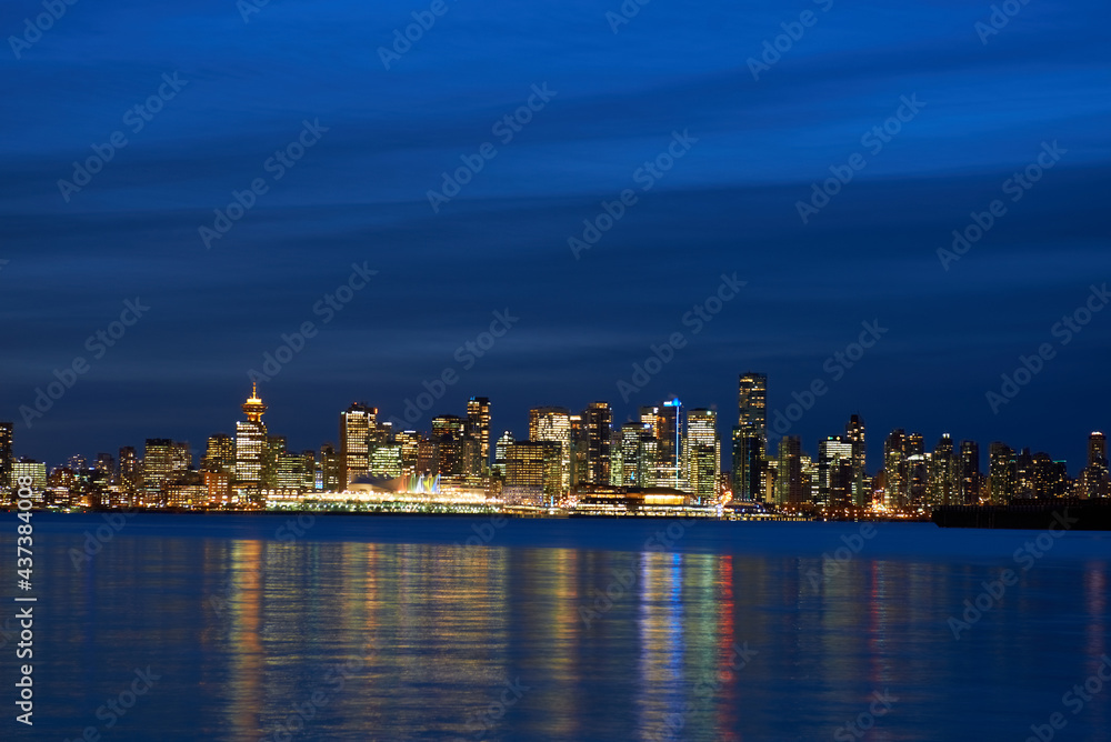 Obraz premium Night city, panoramic scene of downtown reflected in blue water. Vancouver, Canada