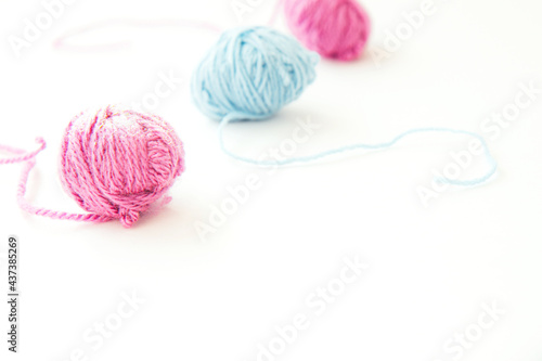 Three skeins of multi-colored woolen yarn on light background with copy space. Close up