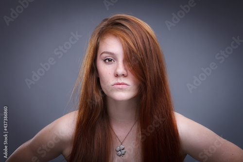 A beautiful young woman with red curly long hair posing at studio. Beauty woman portrate. Young woman.