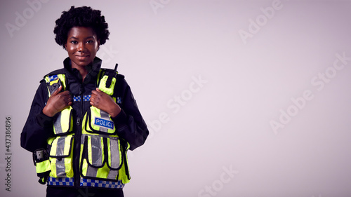 Canvas Print Studio Portrait Of Smiling Young Female Police Officer Against Plain Background
