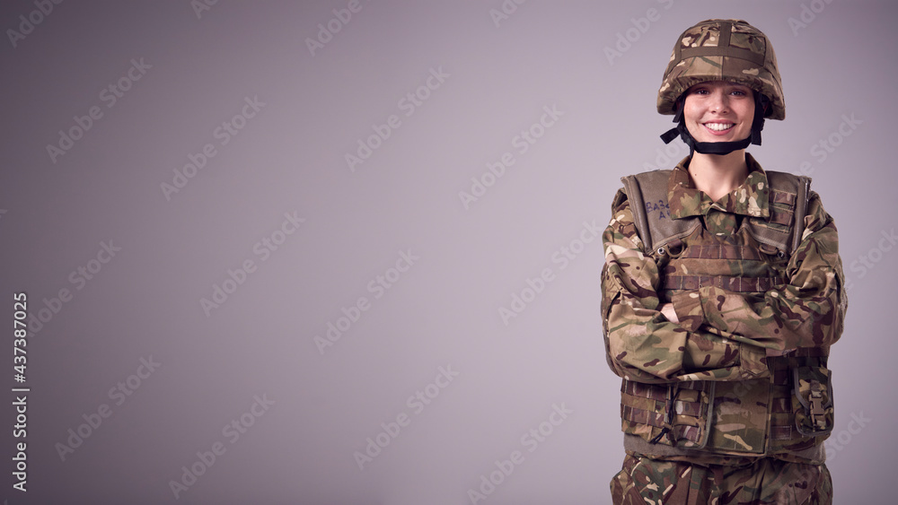 Studio Portrait Of Smiling Young Female Soldier In Military Uniform Against Plain Background Studio Portrait Of Smiling Young Female Soldier In Military Uniform Against Plain Background