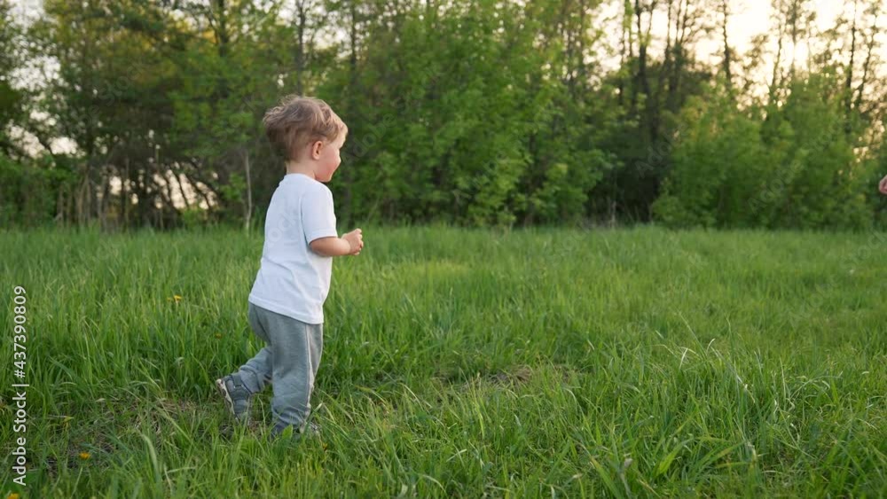 Happy kid run in park. Mom and baby play outdoors. Happy family concept. Smile of a baby. Kid play in park. Happy family in park. Kid smile and run. Baby dream. Mom and baby family games.