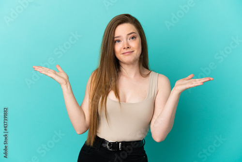 Teenager girl over isolated blue background making doubts gesture