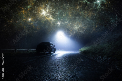 A lone car, parked on the side of the road, underneath a street light, on a spooky country road. On a foggy winters night. With apocalyptic clouds of energy glowing in the sky. © Dave