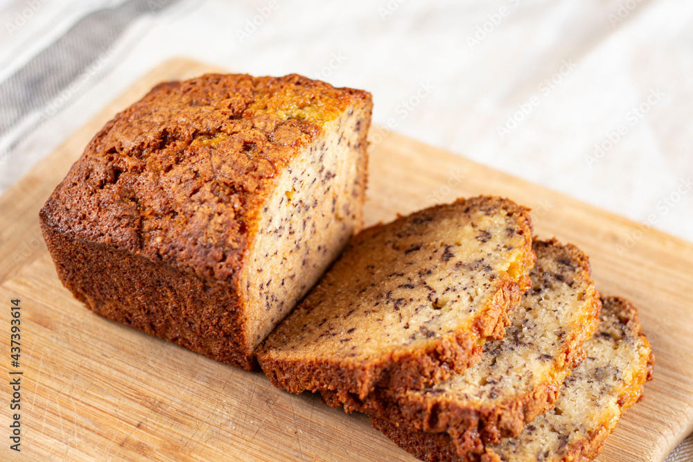 Sliced loaf of banana bread cupcake with poppy seeds on cooling wrack