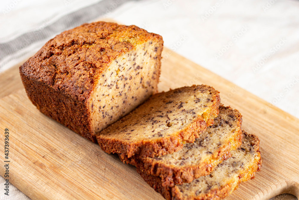 Sliced loaf of banana bread cupcake with poppy seeds on cooling wrack Sliced loaf of banana bread cupcake with poppy seeds on cooling wrack