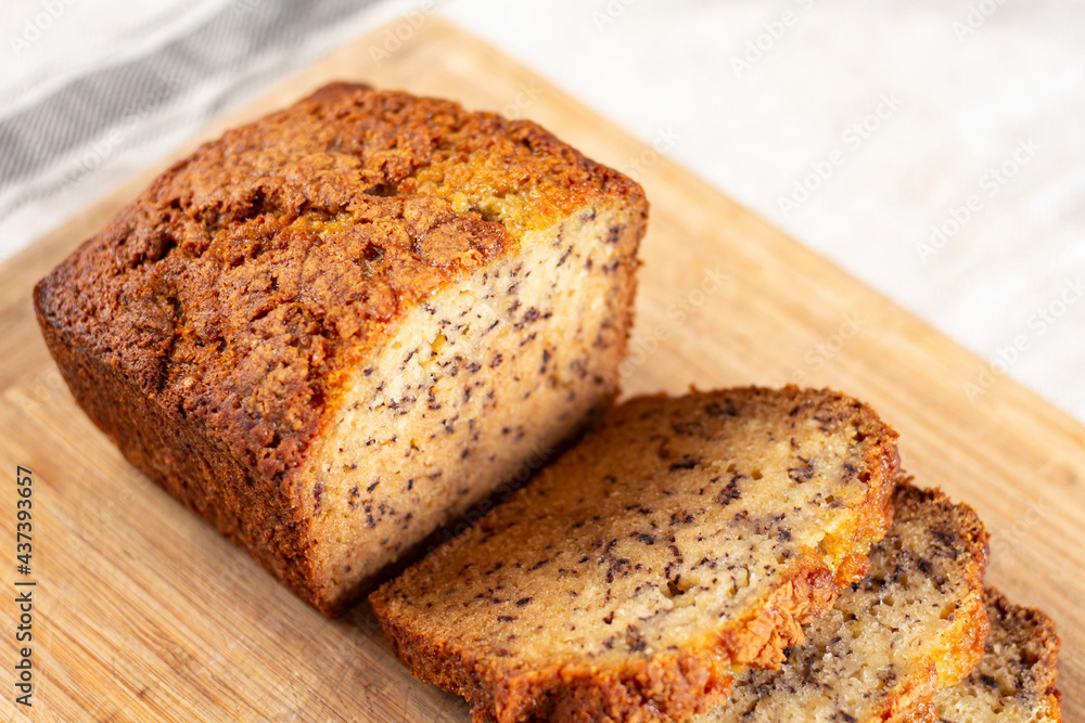 Sliced loaf of banana bread cupcake with poppy seeds on cooling wrack Sliced loaf of banana bread cupcake with poppy seeds on cooling wrack