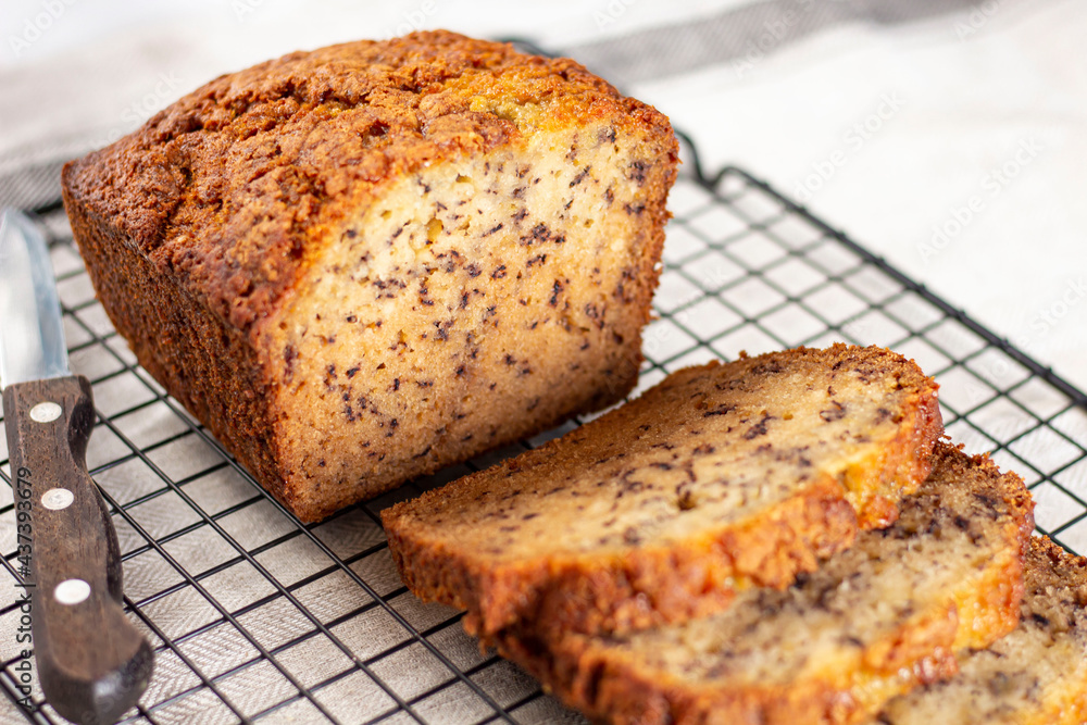 Sliced loaf of banana bread cupcake with poppy seeds on cooling wrack Sliced loaf of banana bread cupcake with poppy seeds on cooling wrack