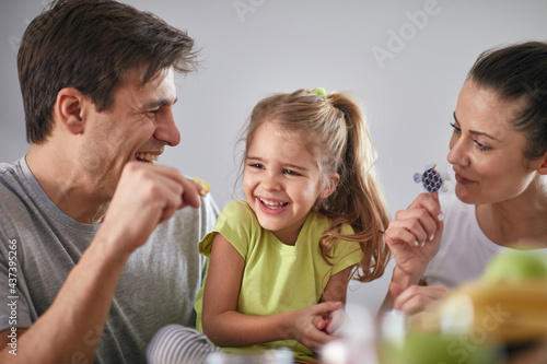 A young parents having a good time with their daughter after a breakfast at dining room. Family, together, breakfast, home photo