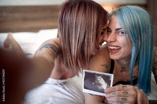 Joyful lgbt couple sharing a pregnancy test results