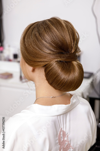 hairstyle low bun on light brown straight hair for the bride on the wedding day