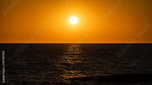 Sunset over Black Sea. Close-up. Beautiful multicolored clouds. Sea water glows in rays of setting sun. Atmosphere of tranquility and relaxation. Spring evening in Adler. Soc