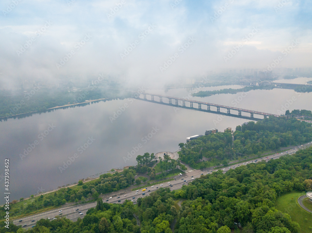Fototapeta premium High view of the Dnieper River in Kiev through the clouds. Spring cloudy morning. Aerial high view.