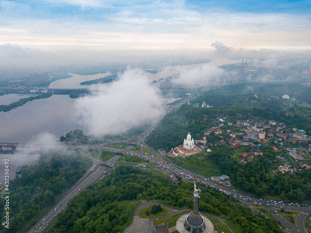Fototapeta premium High view of the Dnieper River in Kiev through the clouds. Spring cloudy morning. Aerial high view.