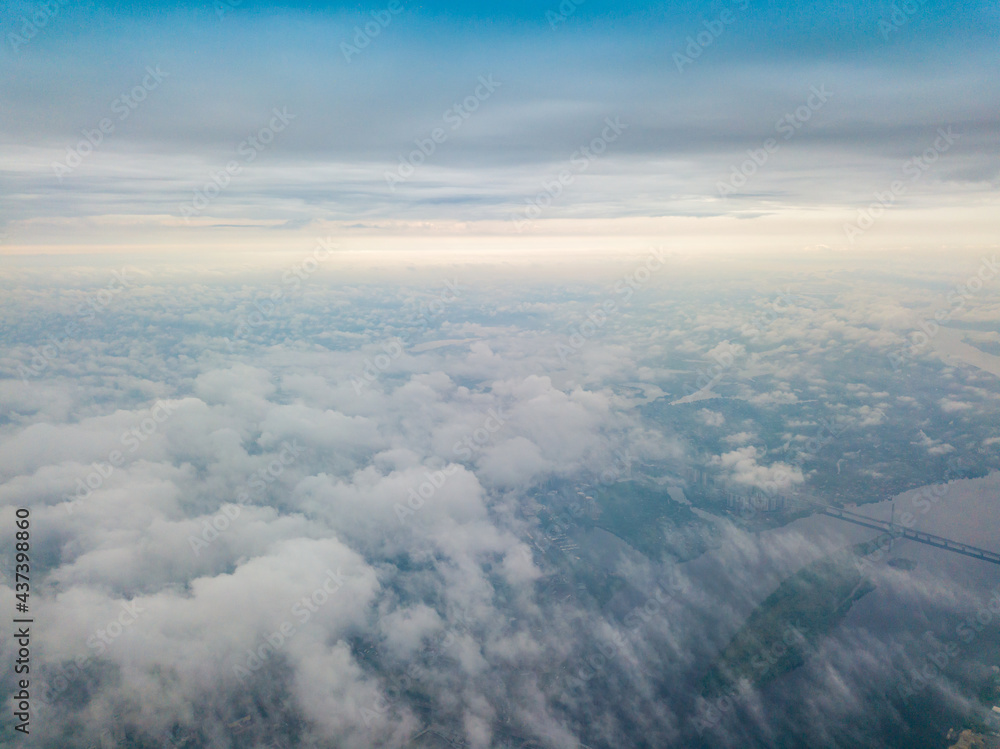 High flight above the clouds in Kiev. Spring cloudy morning. Aerial high view.