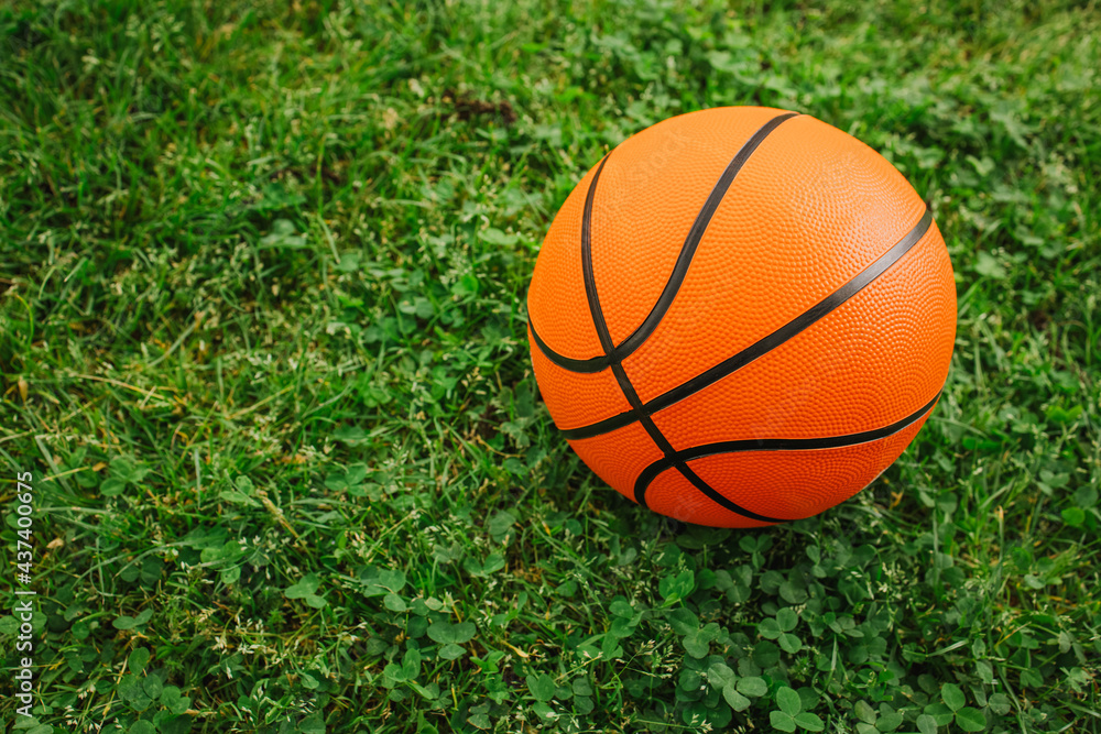 Basketball ball on a fresh green grass. Outdoor kids playground. Basketball ball on a fresh green grass. Outdoor kids playground.