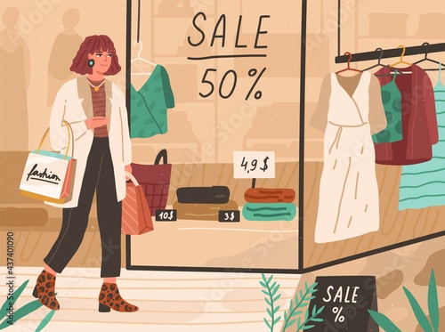 Young happy woman walking in shopping mall, looking at showcases with sale in...
