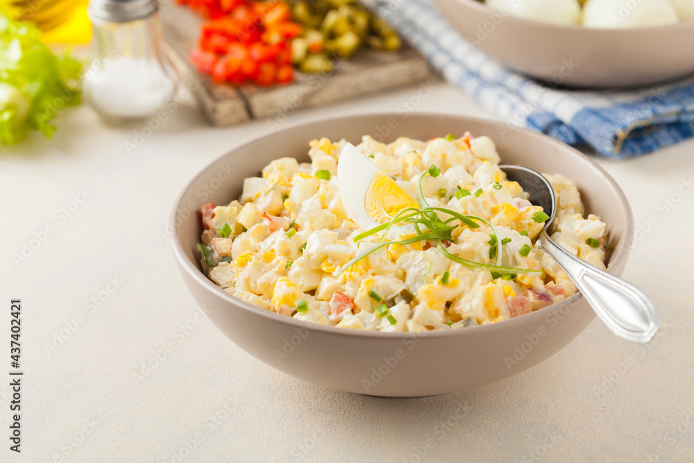A light egg salad with celery, gherkin, pepper and mayonnaise. Served in a bowl on a light background. Front view. A light egg salad with celery, gherkin, pepper and mayonnaise. Served in a bowl on a light background. Front view.