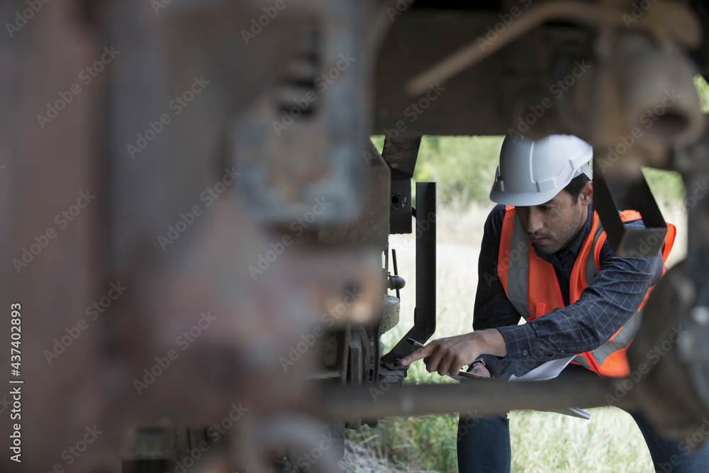 worker service and checking  undercarriage of train bogies.