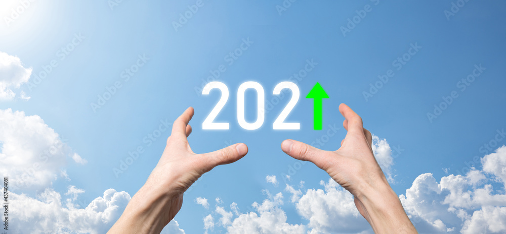 Hand hold 2021 positive icon on sky background.Plan business positive growth in year 2021 concept. Businessman plan and increase of positive indicators in his business, Growing up business concepts. Hand hold 2021 positive icon on sky background.Plan business positive growth in year 2021 concept. Businessman plan and increase of positive indicators in his business, Growing up business concepts.
