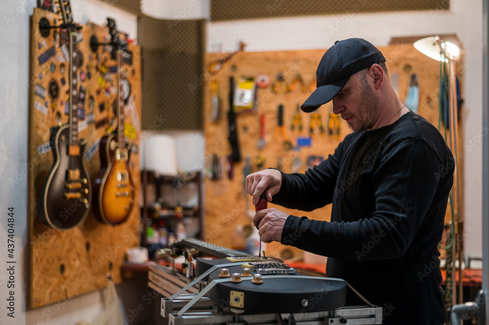Obraz premium Black electrical guitar in repair service shop
