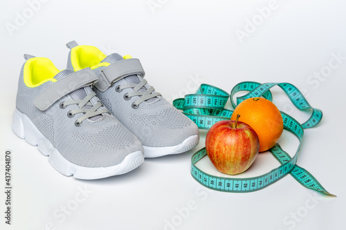 Set for start active healthy lifestyle, weight loss concept, fruits dieting, measuring tape and sneakers on gray background