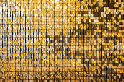 Gold glittering squares on the wall, interior decor, background.