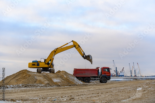 Yellow excavator working on construction site. The road construction.