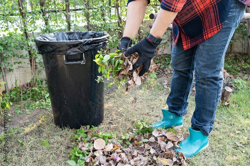 Asian woman clean and collecting bin dry leaves garbage in park, recycle, environment protection. Team with recycle project outside.