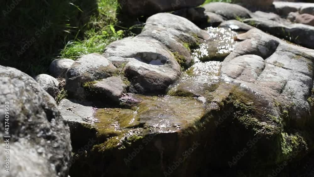 Water runs over the stones. A stream among stones on an alpine slide. Landscaping in the yard. Stream of water among the cobblestones. Water runs over the stones. A stream among stones on an alpine slide. Landscaping in the yard. Stream of water among the cobblestones.