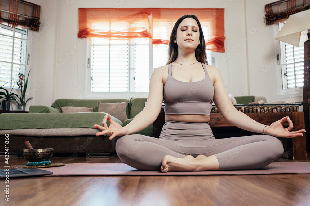 Young girl doing yoga at home in lotus position. Lifestyle concept. Young girl doing yoga at home in lotus position. Lifestyle concept.