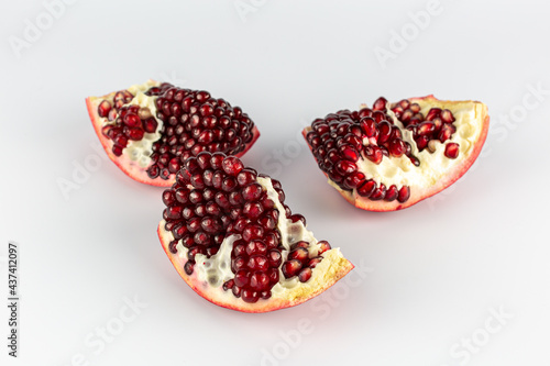 three pomegranate slices on a white background
