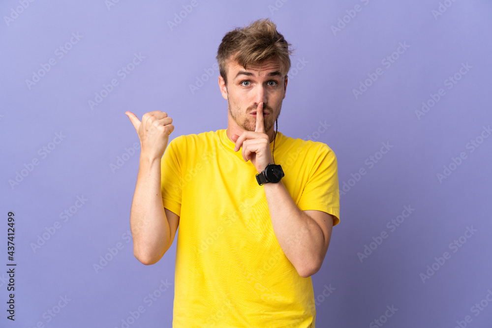 Young handsome blonde man isolated on purple background pointing to the side and doing silence gesture Young handsome blonde man isolated on purple background pointing to the side and doing silence gesture