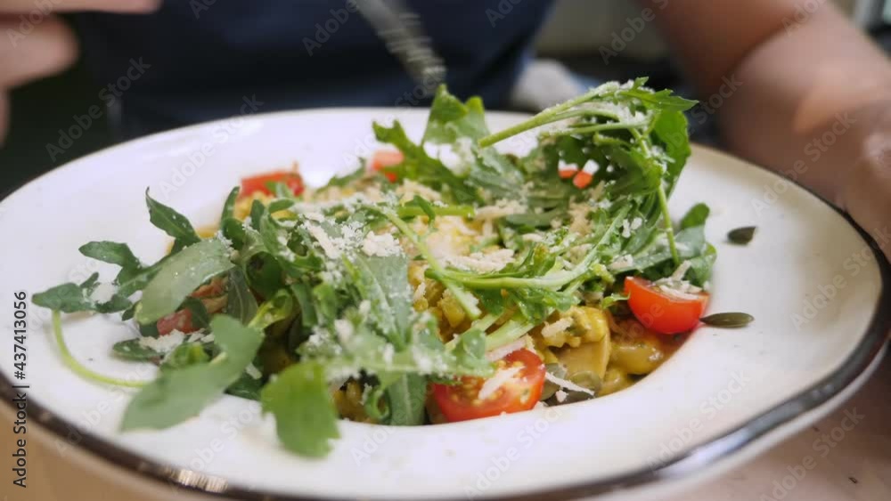 closeup, someone eating with a fork vegan barley dish with turmeric and microgreens closeup, someone eating with a fork vegan barley dish with turmeric and microgreens