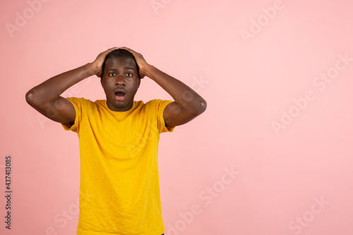 Why is that. Beautiful afro male half-length portrait isolated on trendy studio backgroud. Young emotional surprised, frustrated and bewildered man. © master1305