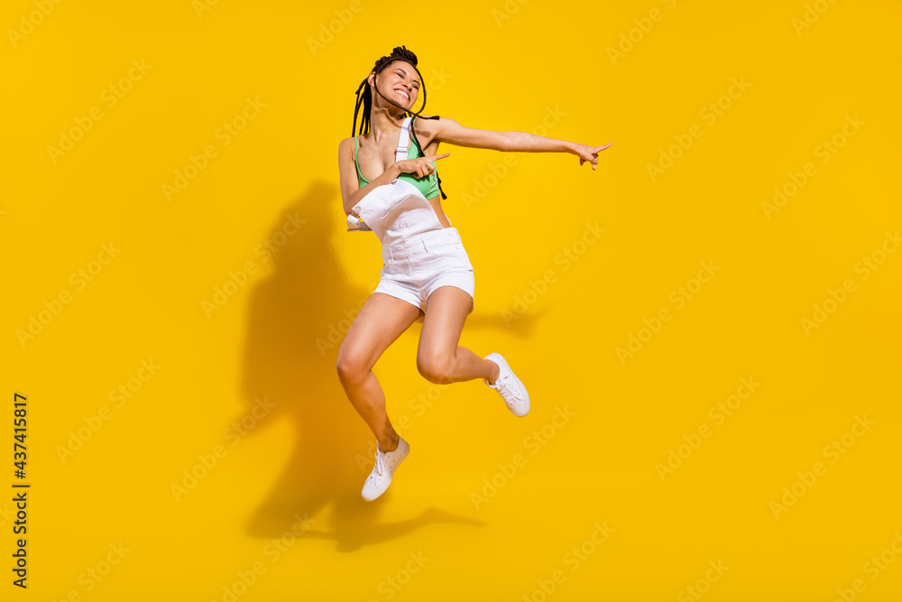 Full body photo of afro american funky happy young woman jump up dance isolated on yellow color background