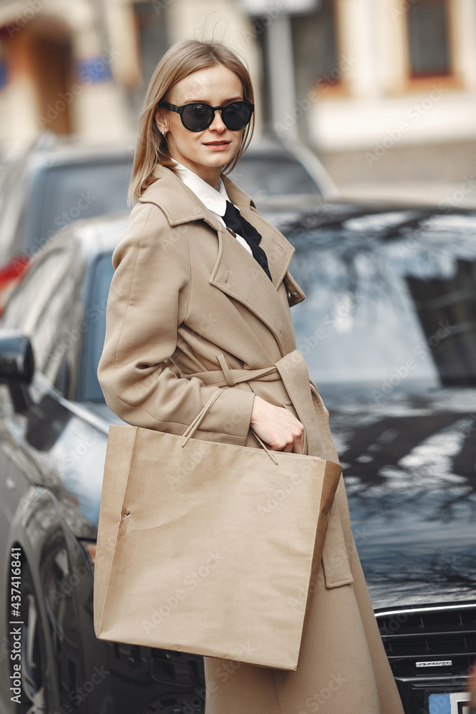 Obraz premium Woman standing by the car with shopping bags
