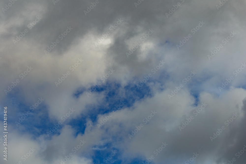 Dark storm clouds on a bright blue sky. Sky patterns background 2021. Dark storm clouds on a bright blue sky. Sky patterns background 2021.