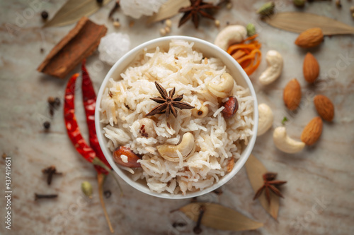 Close-up of Indian Basmati Rice or Kasmiri pulao (pulav) or Dry Fruits Pulao garnished with dry fruits and spices in a ceramic bowl. photo