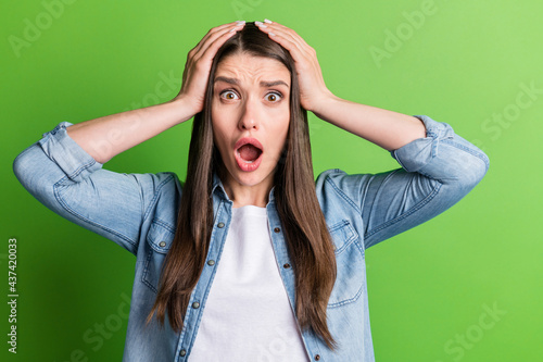 Portrait of attractive desperate girl grief bad news reaction panic isolated over bright green color background photo