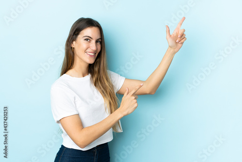 Young caucasian woman over isolated background pointing with the index finger a great idea