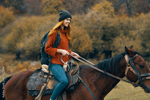 cheerful woman hiker riding a horse adventure mountains fresh air