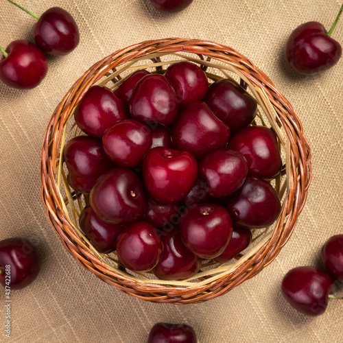 Cherry in a wicker basket on linen
