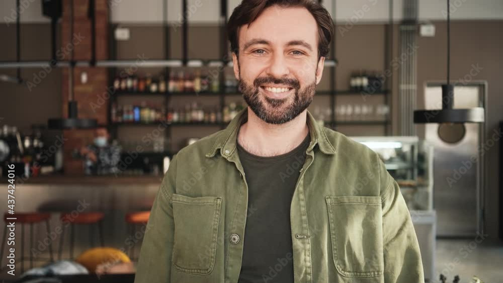 A confident man is posing standing inside the cafe A confident man is posing standing inside the cafe
